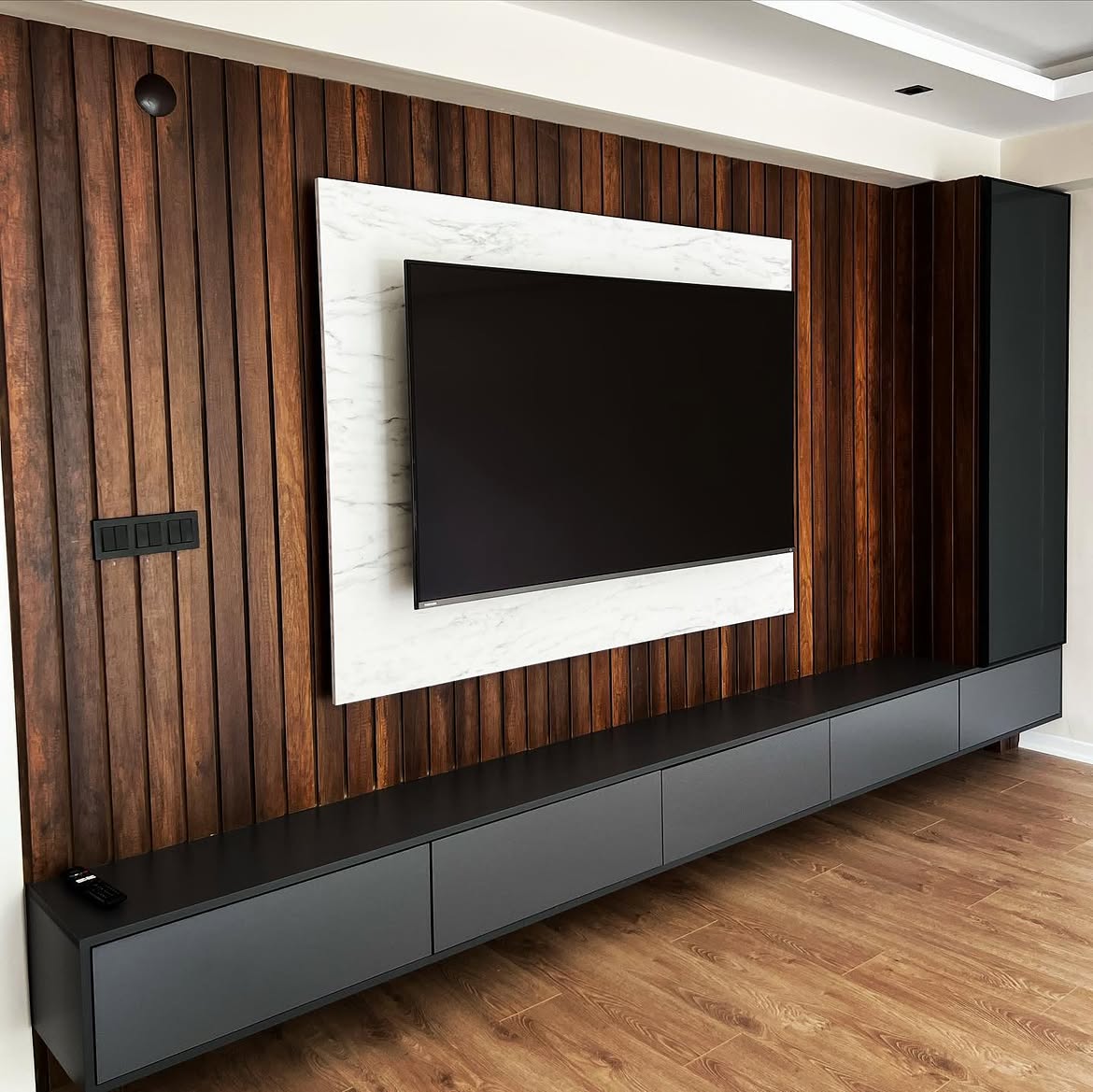 Ahşap çıtalı duvar paneli, mermer desenli TV paneli ve antrasit alt üniteli TV duvarı